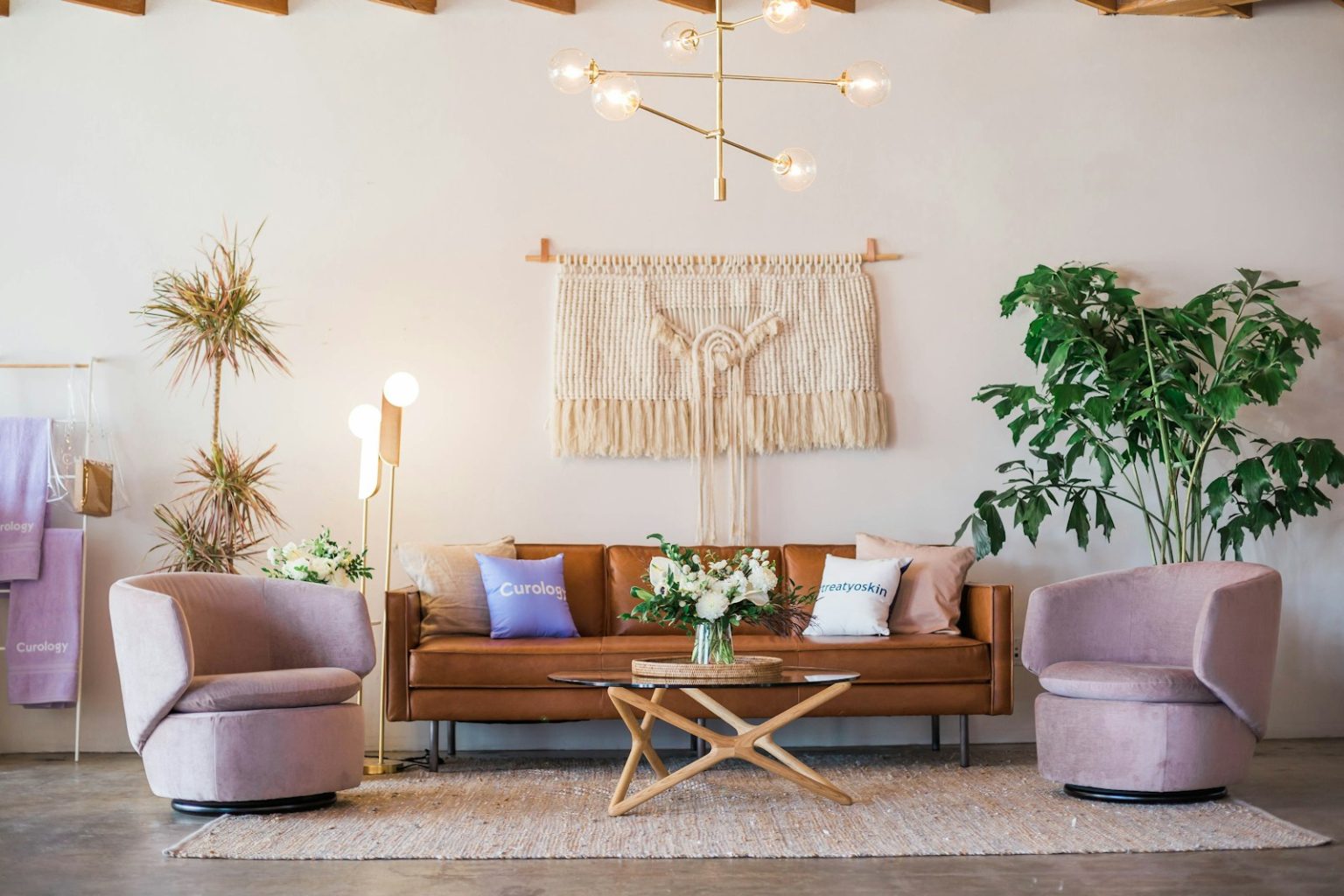 Photo by Curology brown leather sofa and two pink sofa chair