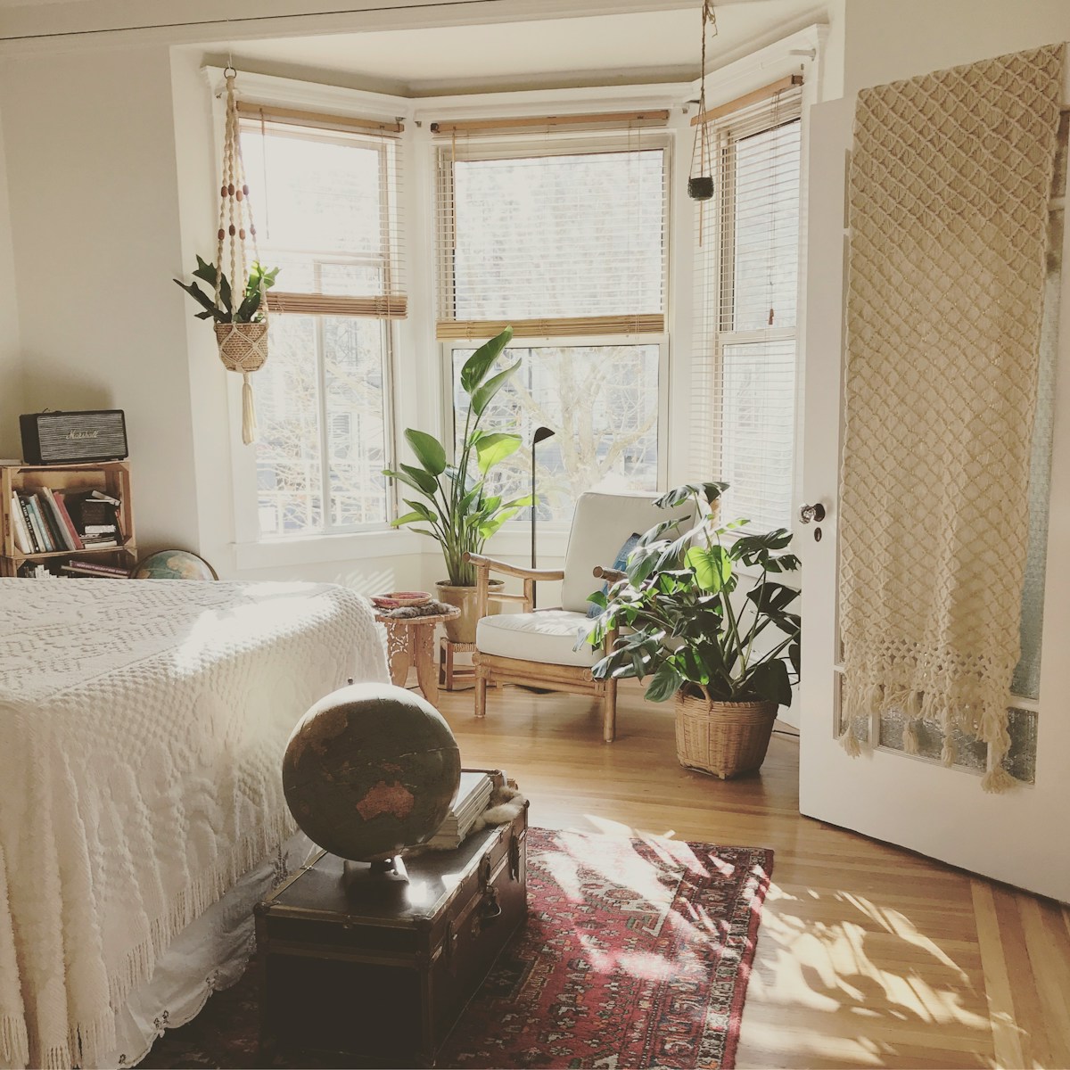 Photo by Timothy Buck brown wooden framed white padded chair in between green indoor leaf plants inside bedroom