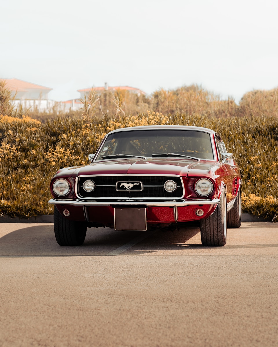 Photo by Tiago Ferreira A red car parked on the side of a road